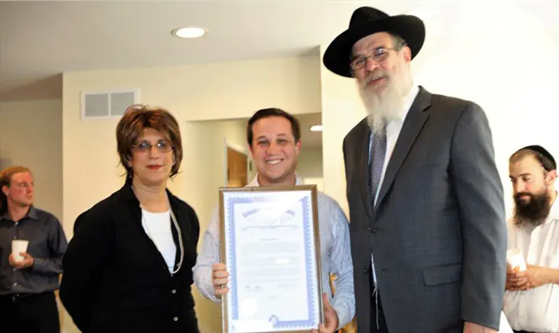 State Representative Robert Wittenberg presents official proclamation to Rabbi Herschel Finman and Chand Finman