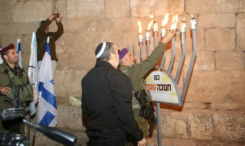 Lighting Hanukkah candles in as-Samu