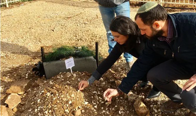 שקד מניחה אבן על קברו של הרב שבח הי"ד