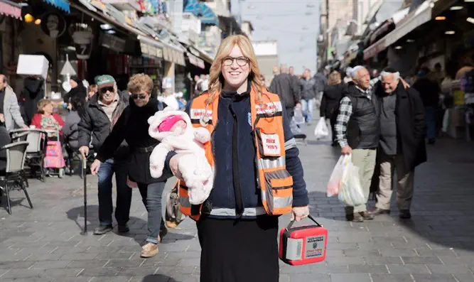 Miriam Ballin, holding her baby daughter, at the Mahane Yehuda market in Jerusalem.