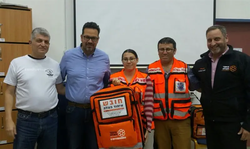 Regional paramedic Revital Curiel and EMT Avi Elchiani receive donated medic kits.