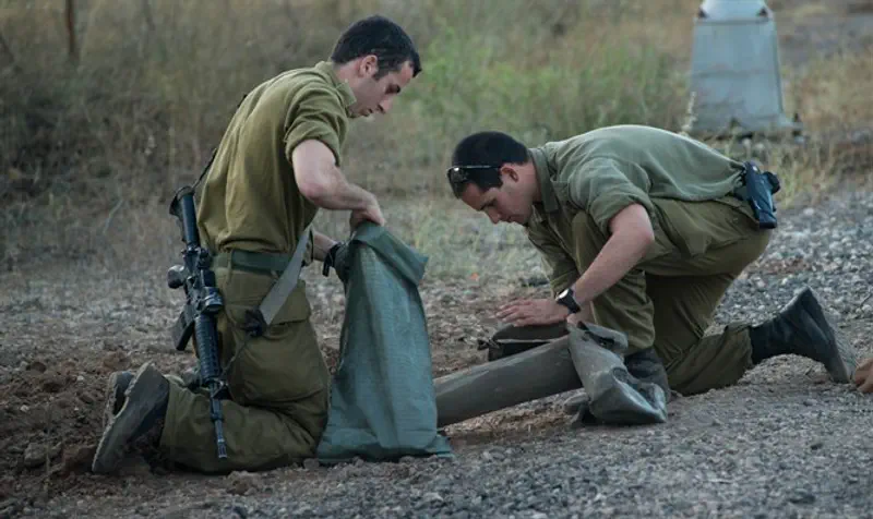 Soldiers collecting remains of rocket fired from Syria into Israel, Golan Hts