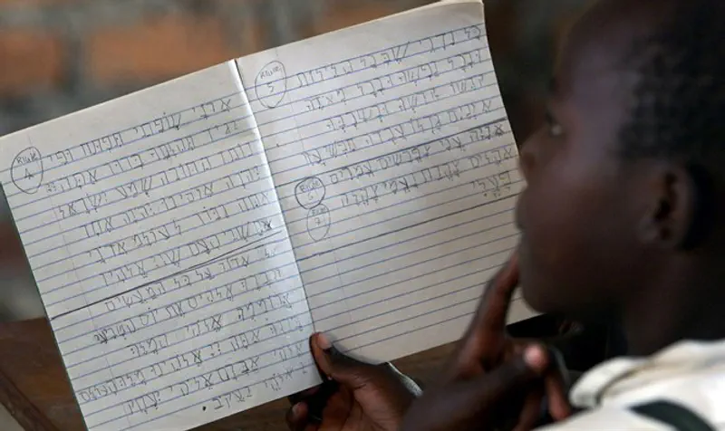 Ugandan School girl goes through Hebrew writing lesson at Hadassah School