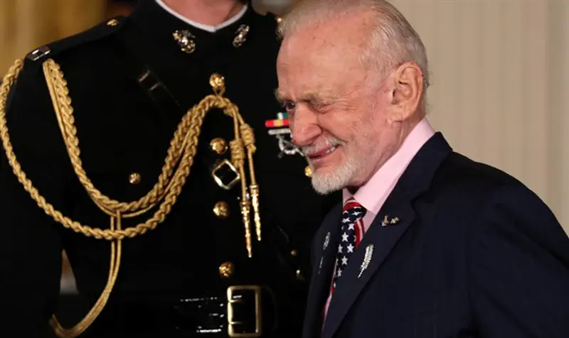 Former U.S. astronaut Buzz Aldrin winks at a fellow attendee as he arrives