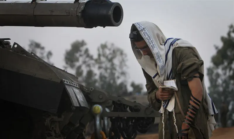 Armored Corps soldier prays before operation near Gaza