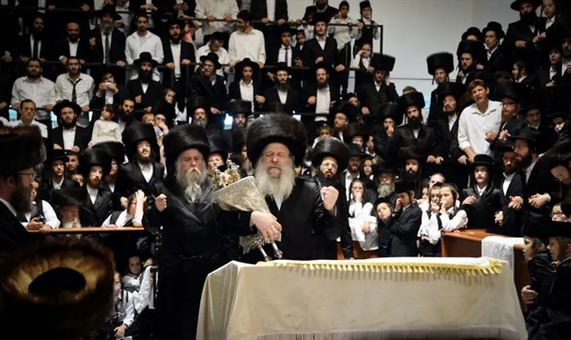 Jewish men of Chasidic Nadvorna dynasty carry Torah scroll on Simchat Torah