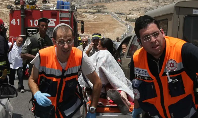 MDA paramedics rush woman from accident scene, north of Jerusalem