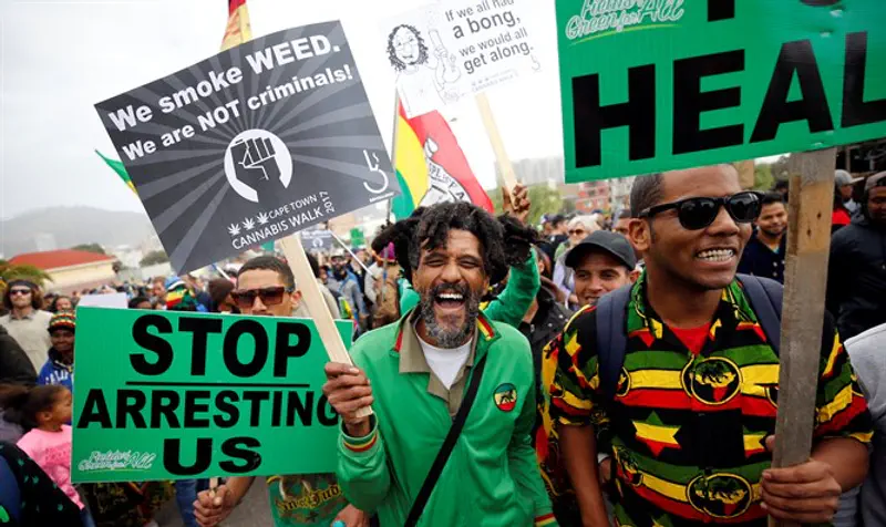 Demonstrators hold placards during march calling for cannabis legalization