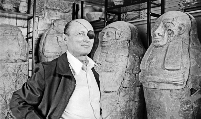 Moshe Dayan, standing next to anthropoid coffins, at his home in Zahala, 1976