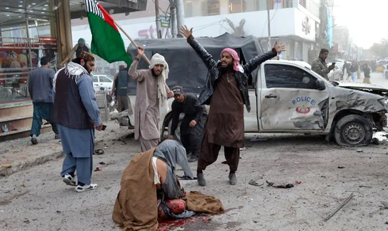 Wounded man sits on ground after bomb blast in Quetta