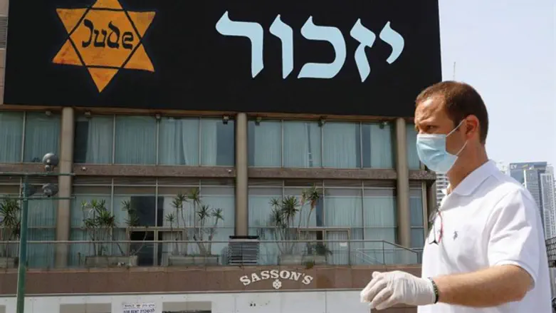Man in front of banner in Tel Aviv, April 2020