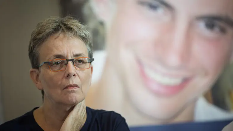 Leah Goldin standing in front of a picture of her son, Hadar