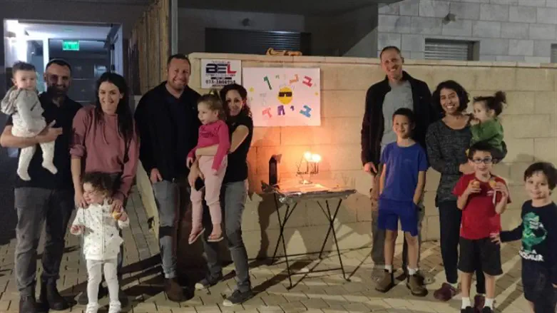 Lighting the Hanukkah menorah with neighbors