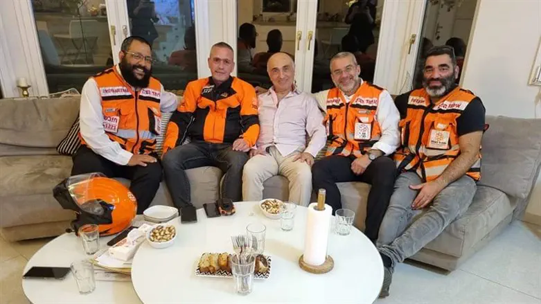 EMTs Aviran, Eliran, Malachi, and Golan sitting with the man whose life they saved