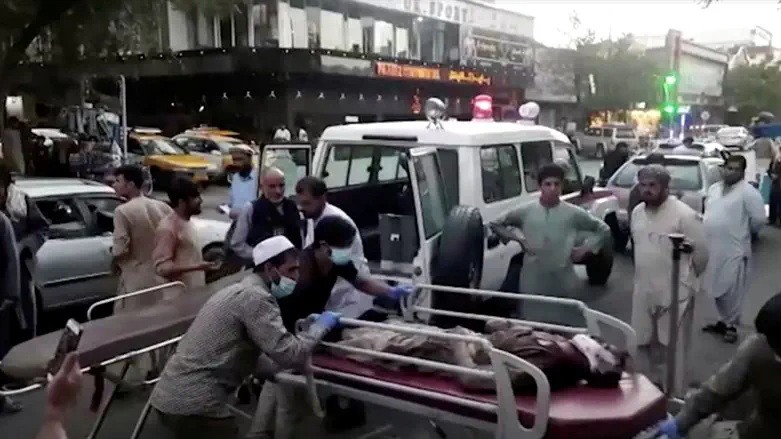People carrying an injured person to a hospital after an attack at Kabul airport