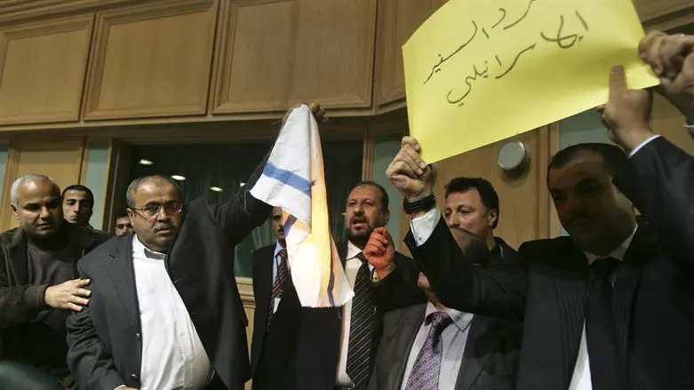 Khalil Atiyah (2nd L) holds a burning Israeli flag in the Jordanian Parliament