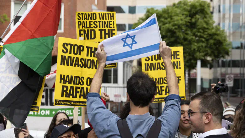 Man holds an Israeli flag while counter-demonstrating against a pro-Palestinian protest