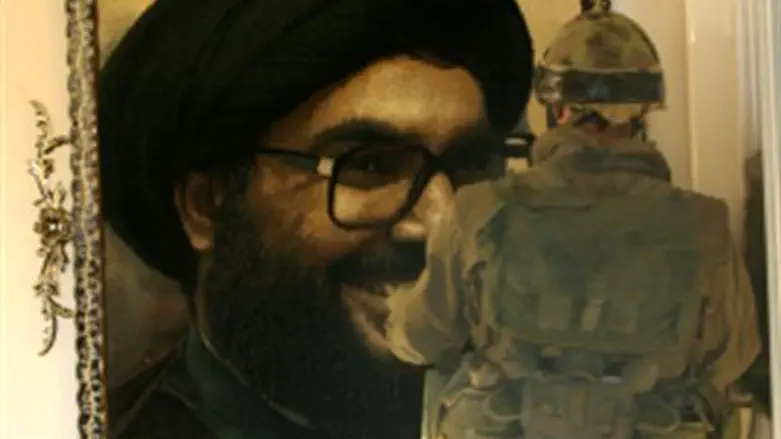 IDF soldier looks at portrait of Nasrallah