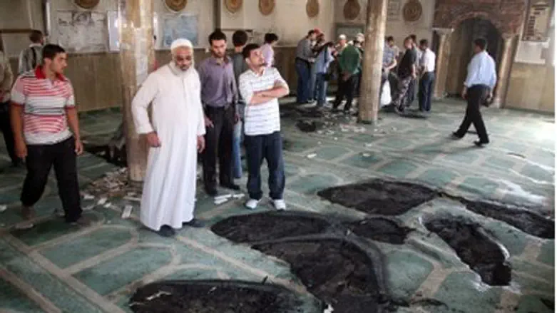 Muslims inspect partially burnt mosque