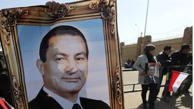 Mubarak supporters hold up his photo