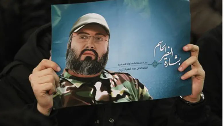 Hizbullah supporter holds a poster of Mughniy