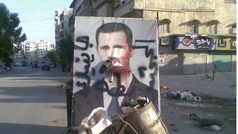A defaced poster of Syria's President Bashar 