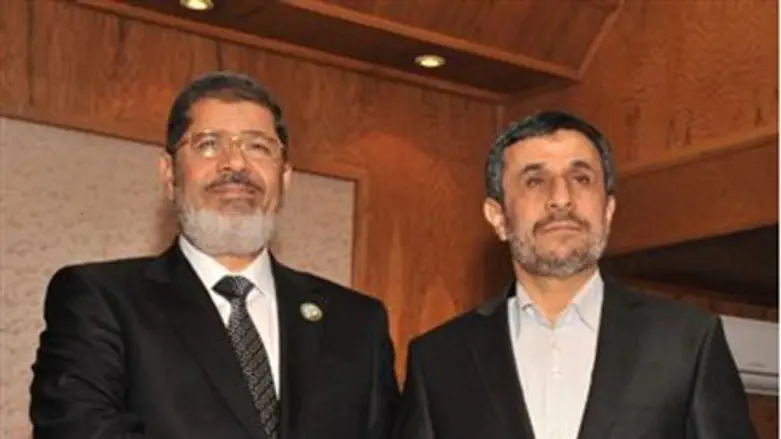 Morsi shakes hands with Ahmadinejad at the re