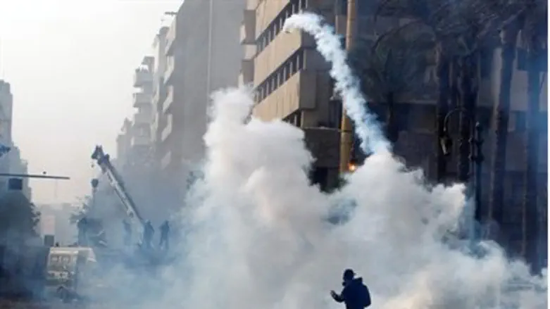 A protester returns a tear gas canister to th