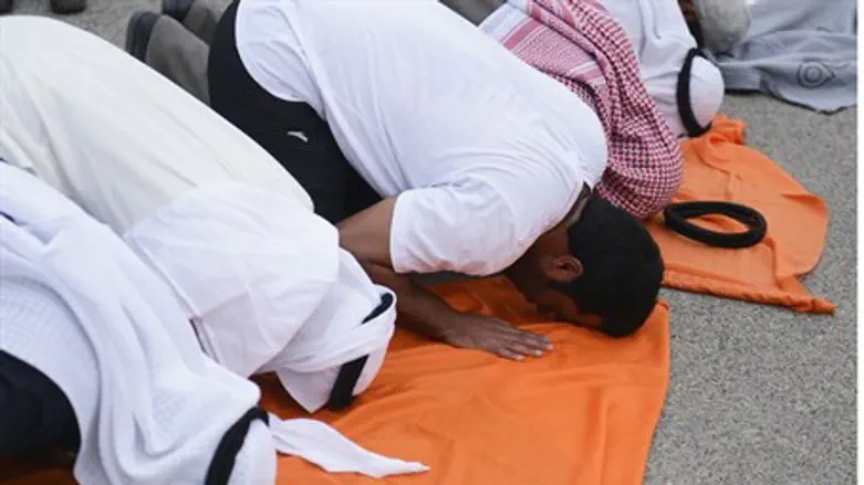 Kuwaiti protesters pray before marching