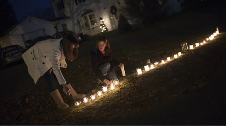 Residents light candles in their front yard f