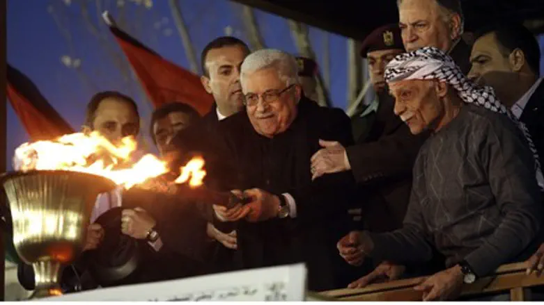 Abbas lights a torch during a rally marking t
