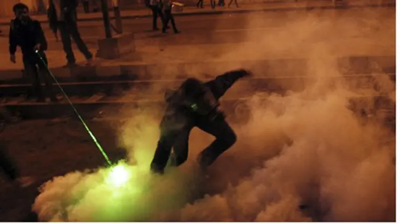Anti-government protester hurls tear gas cann