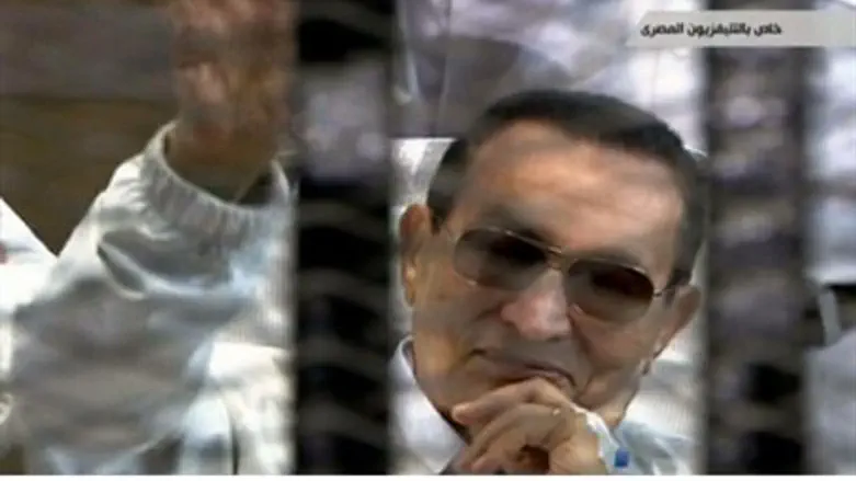 Hosni Mubarak waves from behind bars during h