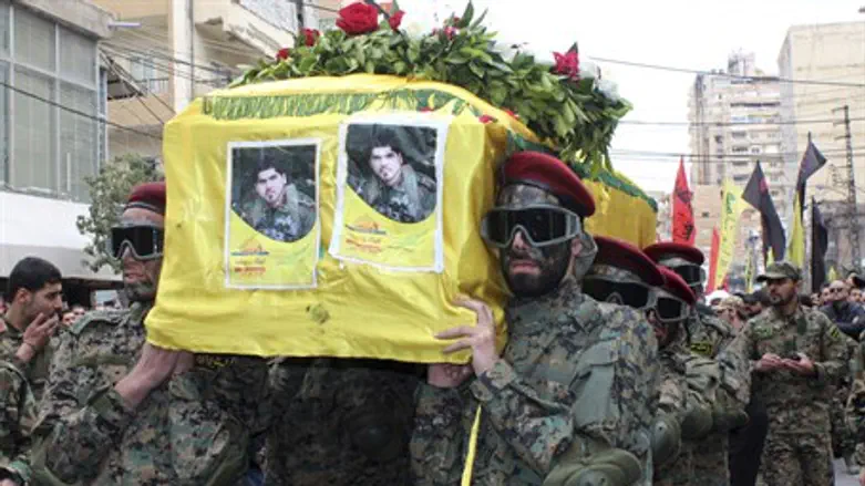 Hezbollah members carry the coffin of a fight