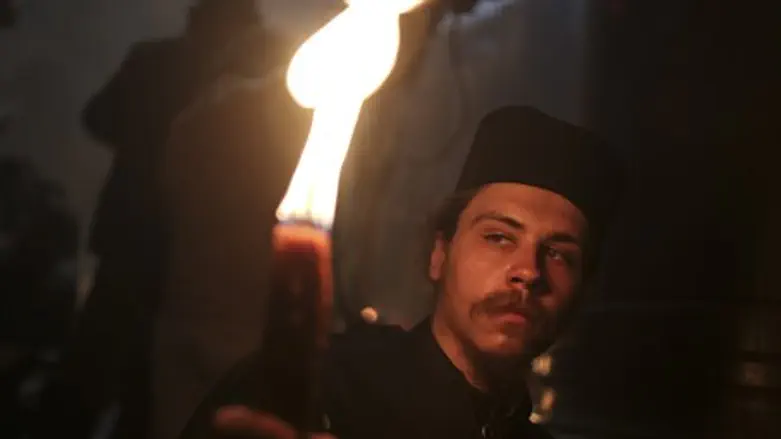 Orthodox Christian pilgrim holds a candle dur