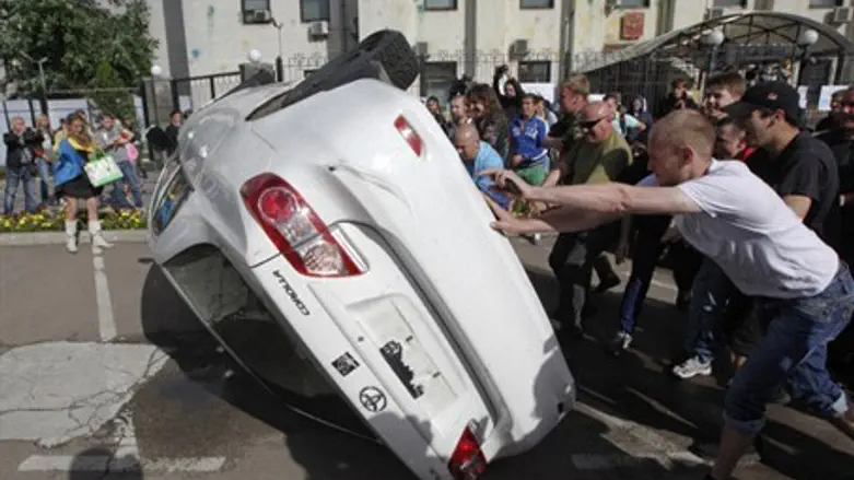 Pro-Ukrainian people overturn a car during a 