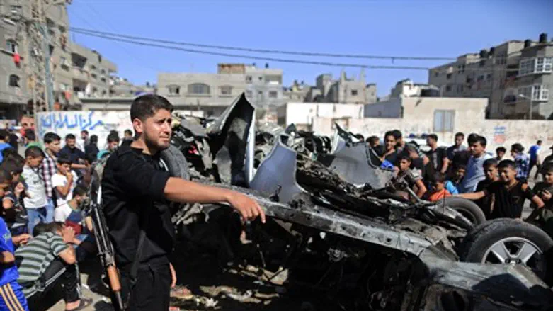 Palestinians gather round wreckage of car tar