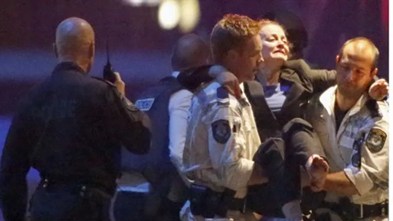 Police evacuate a woman injured during Sydney hostage crisis