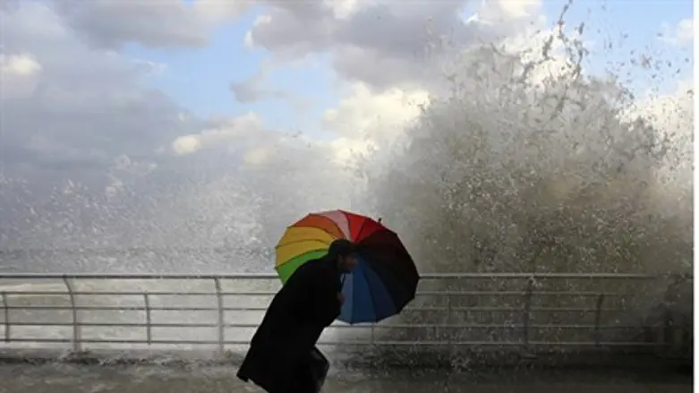 Beirut pedestrian ducks behind an umbrella as powerful winds kick up massive wave - but wo
