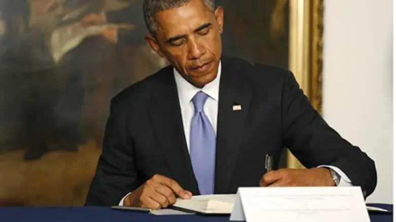 Obama signs a condolences book at the French Embassy in Washington