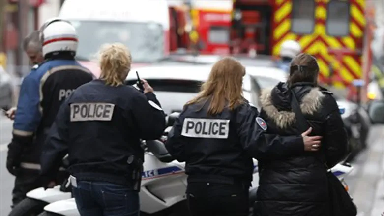 French police assist a woman following Cherlie Hebdo shooting attack