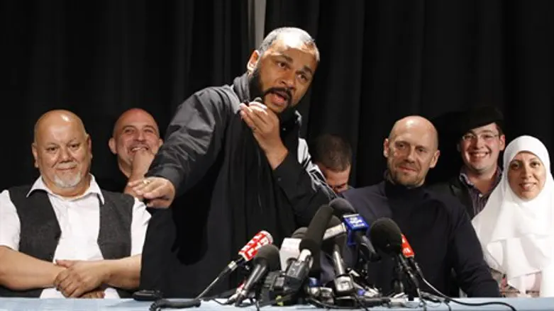 Dieudonne performs the "quenelle" gesture at a news conference