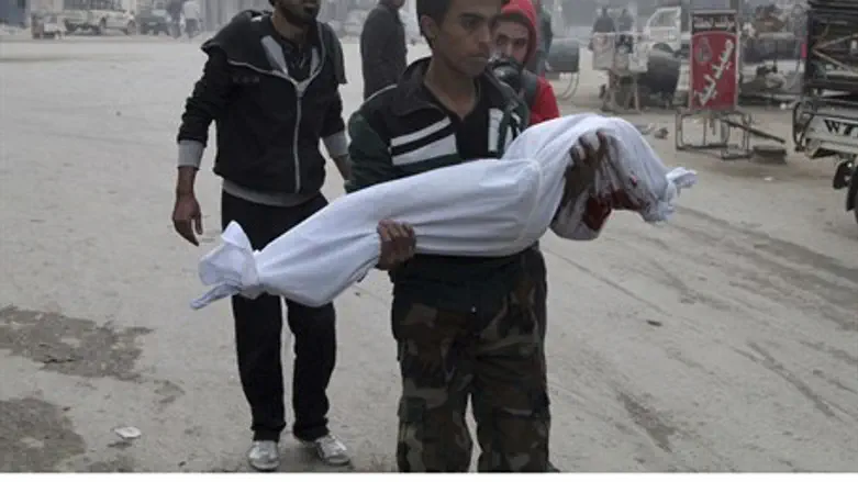 A man holds a child killed by an Assad regime barrel bomb in Aleppo