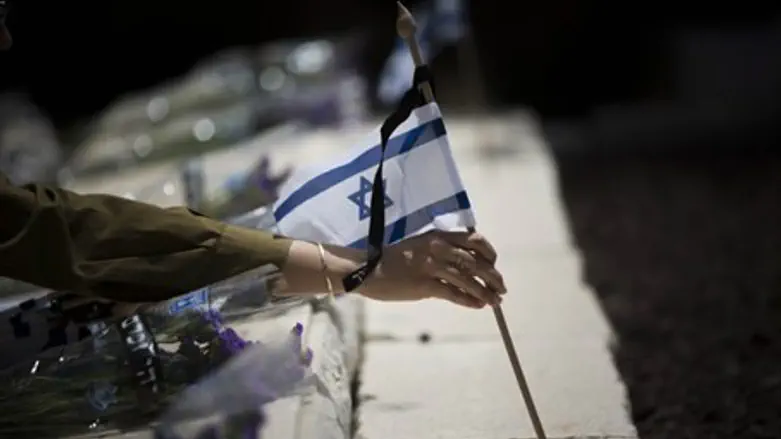 Placing an Israeli flag on a soldier's grave