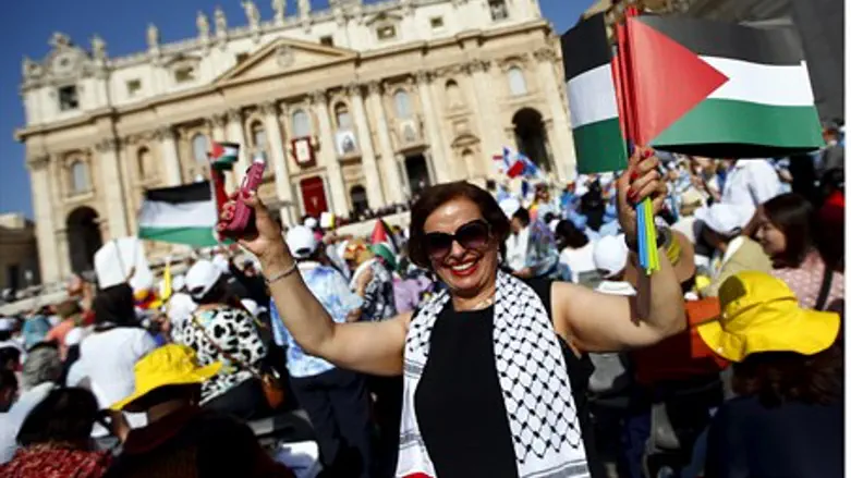 Activists wave Palestinian Authority flag during Vatican canonization of Arab saints