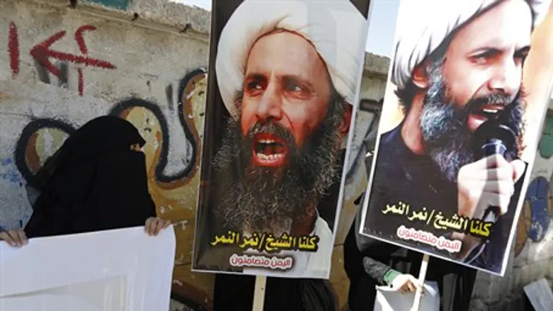 Protesters carry posters of Nimr al-Nimr