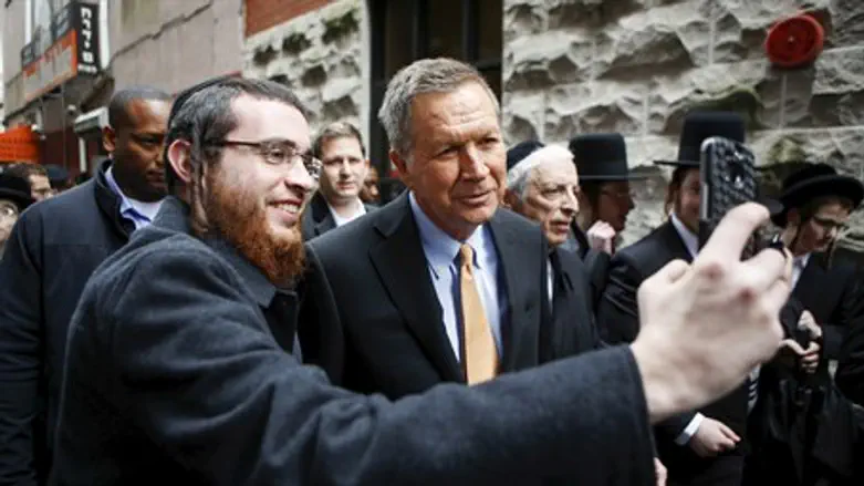 Haredi man takes a selfie with Republican candidate John Kasich in New York