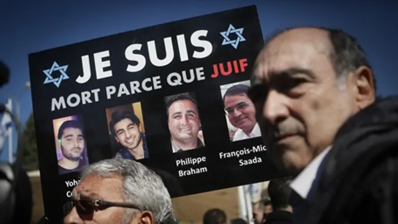 Mourners in Jerusalem hold pictures of Jewish victims of 2015 Paris attacks