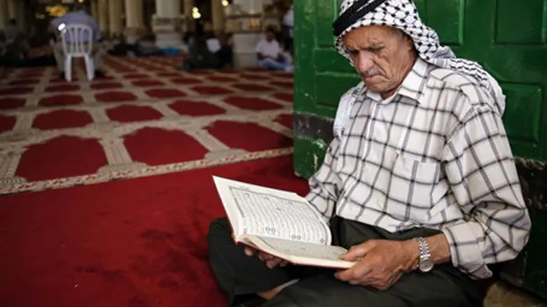 Muslim man reads the Koran during Ramadan at Al Aqsa Mosque