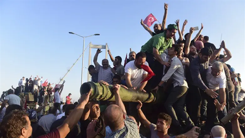 Government supporters celebrate atop tank seized after failed coup